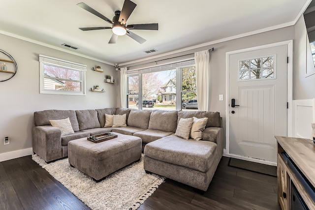 living area featuring dark wood finished floors, visible vents, a wealth of natural light, and ornamental molding