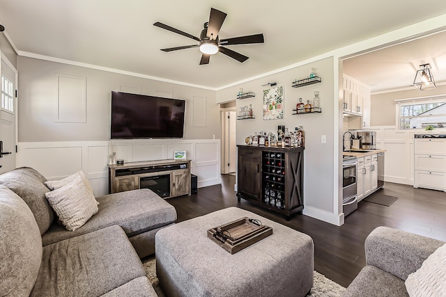 living room with dark wood-style floors, ceiling fan, and crown molding
