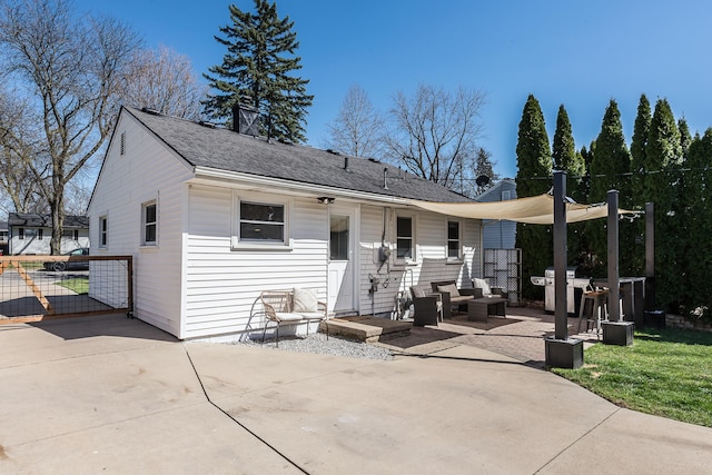 back of house featuring fence, a patio, and a shingled roof