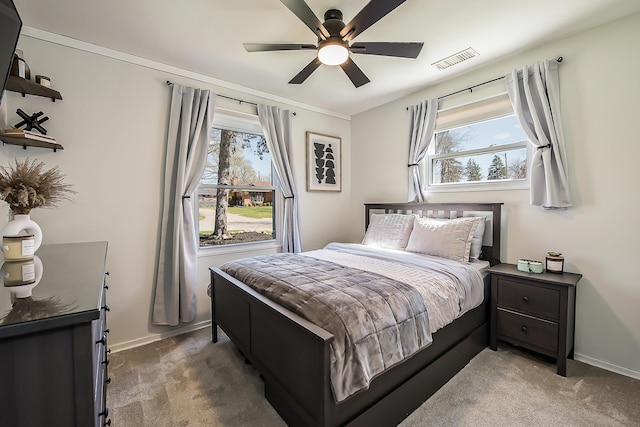 bedroom with baseboards, a ceiling fan, visible vents, and light colored carpet