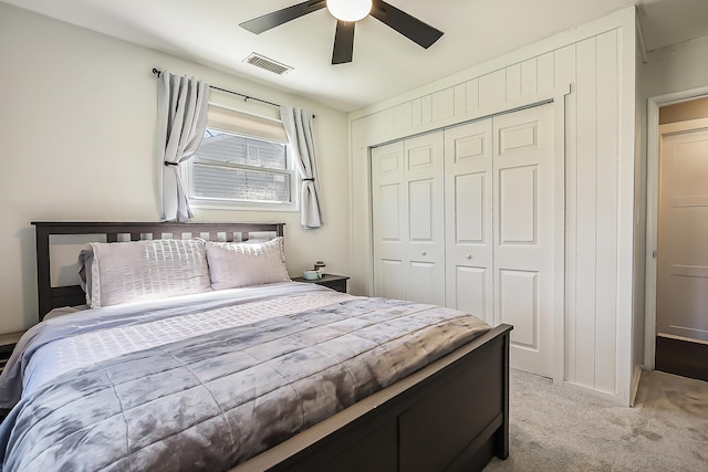 bedroom featuring light colored carpet, ceiling fan, visible vents, and a closet