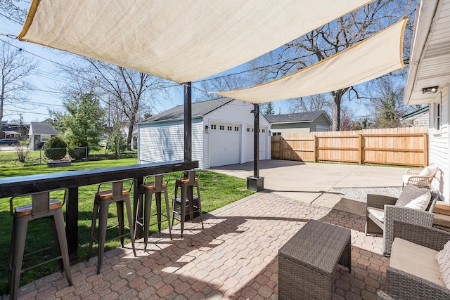 view of patio featuring an outdoor structure, fence, and a garage
