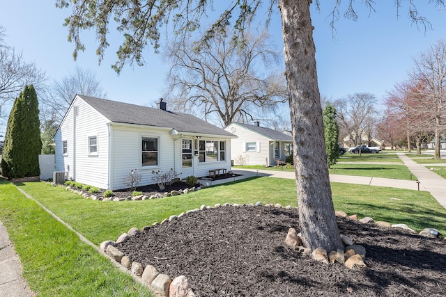 bungalow-style home with a front lawn, a chimney, and central AC unit