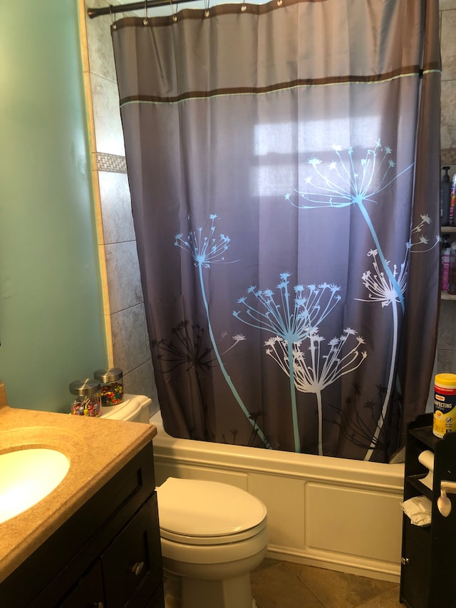 full bathroom featuring tile patterned flooring, toilet, vanity, and shower / tub combo with curtain
