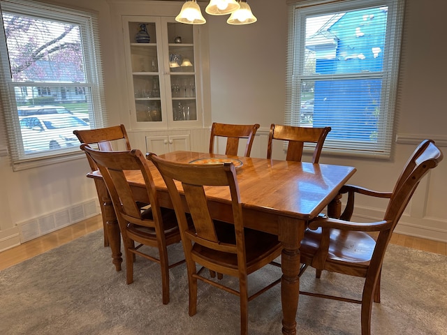 dining space featuring an inviting chandelier, light wood finished floors, and visible vents