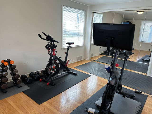 exercise area featuring wood finished floors and visible vents