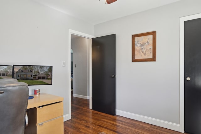 home office with baseboards, ceiling fan, and dark wood-type flooring