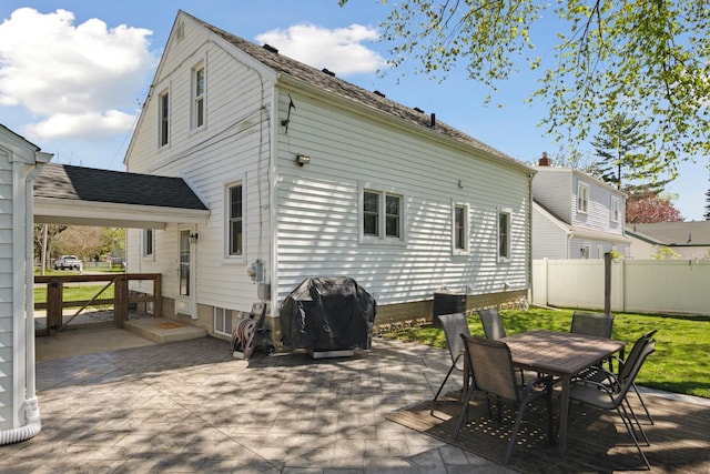 back of property featuring outdoor dining area, a patio area, fence, and cooling unit