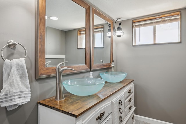 bathroom featuring double vanity, a healthy amount of sunlight, and a sink