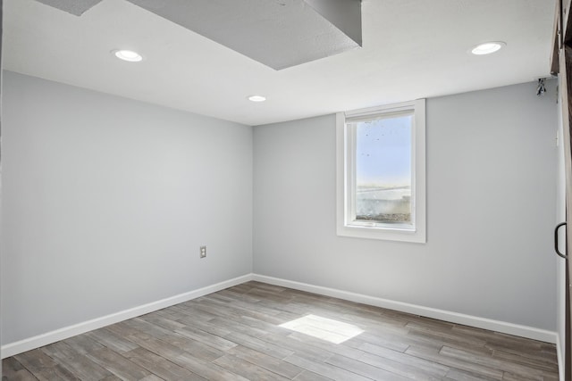 unfurnished room featuring baseboards, recessed lighting, and wood finished floors