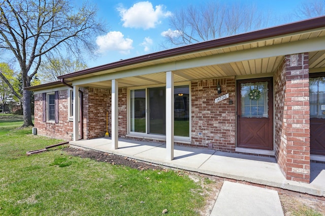 exterior space with a lawn, brick siding, and a porch