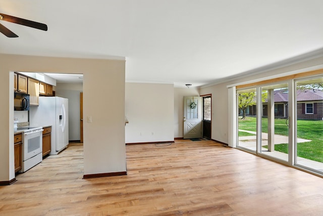 unfurnished living room featuring light wood-style floors, a ceiling fan, baseboards, and crown molding