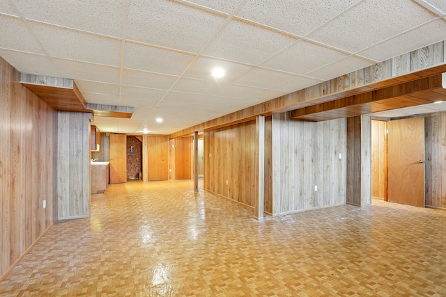finished below grade area with wooden walls and a paneled ceiling