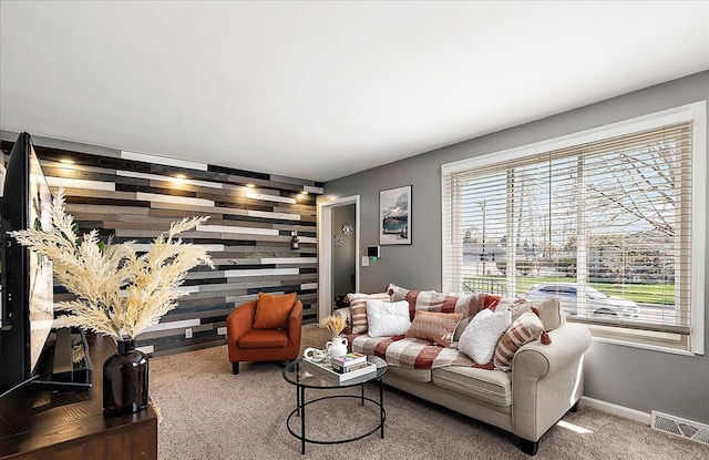 carpeted living area with baseboards and visible vents
