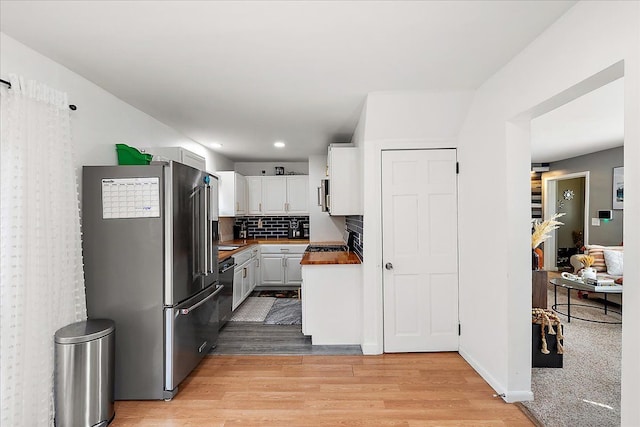 kitchen featuring recessed lighting, stainless steel appliances, white cabinets, backsplash, and light wood finished floors