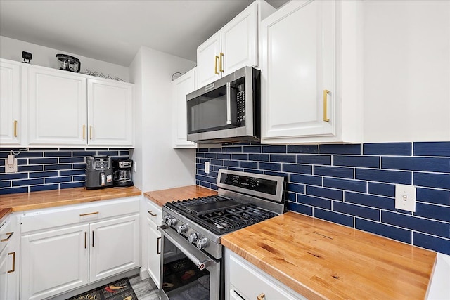 kitchen with backsplash, butcher block countertops, white cabinets, and appliances with stainless steel finishes