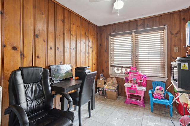 office with wooden walls and a ceiling fan