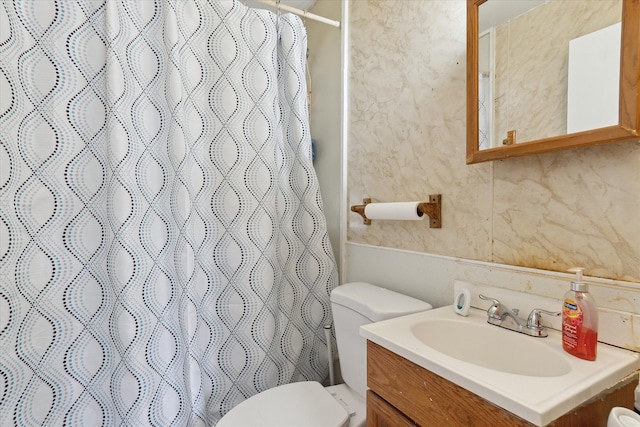 bathroom with toilet, vanity, and curtained shower
