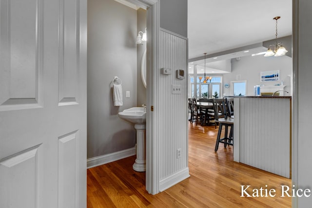 5575 Beechmont Rd, Whitehall, MI 49461 - bathroom featuring baseboards, a chandelier, and wood finished floors