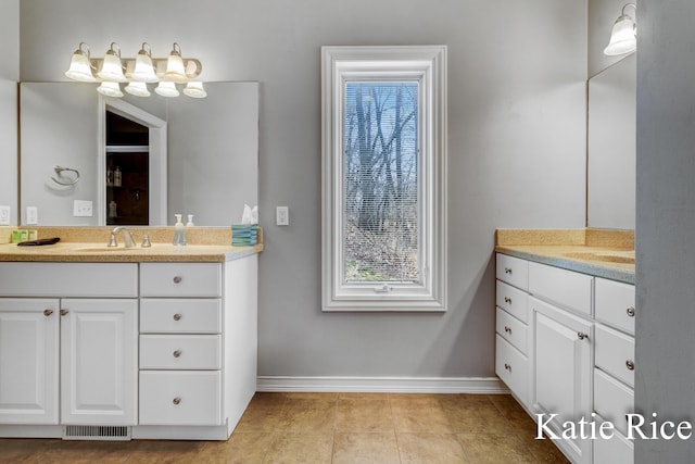 5575 Beechmont Rd, Whitehall, MI 49461 - full bath featuring two vanities, visible vents, baseboards, and a sink