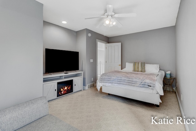 5575 Beechmont Rd, Whitehall, MI 49461 - bedroom featuring baseboards, visible vents, light colored carpet, ceiling fan, and a lit fireplace