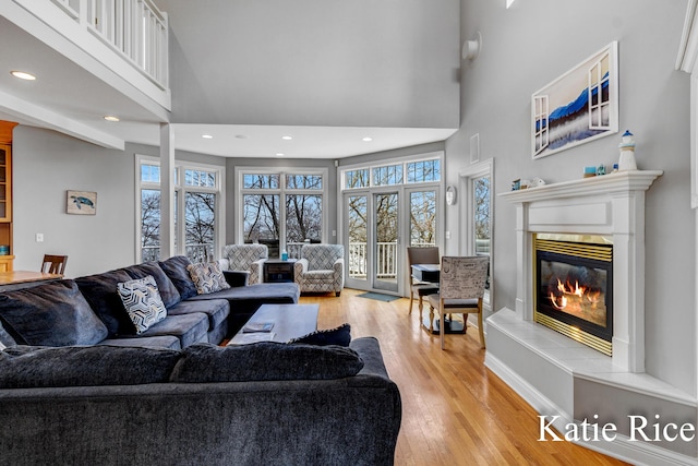 5575 Beechmont Rd, Whitehall, MI 49461 - living area with recessed lighting, a glass covered fireplace, a high ceiling, and light wood-style flooring