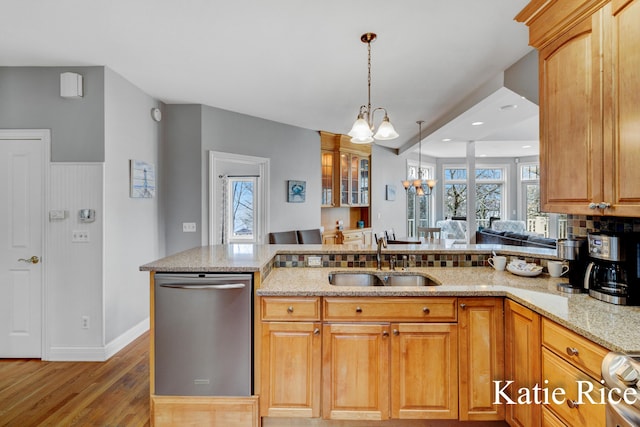 5575 Beechmont Rd, Whitehall, MI 49461 - kitchen featuring stainless steel dishwasher, light wood-style flooring, a sink, a notable chandelier, and light stone countertops