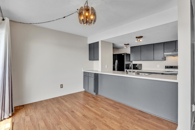 kitchen with a sink, black fridge with ice dispenser, gray cabinetry, under cabinet range hood, and electric stove