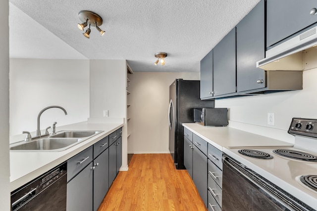 kitchen featuring a sink, dishwasher, electric range oven, light countertops, and under cabinet range hood