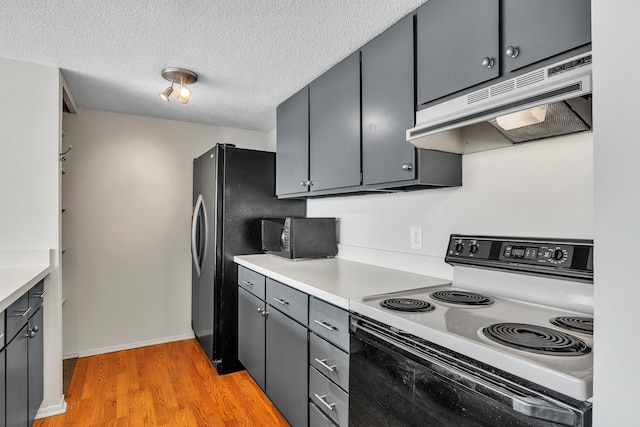 kitchen featuring range with electric cooktop, under cabinet range hood, light countertops, black microwave, and light wood-style flooring