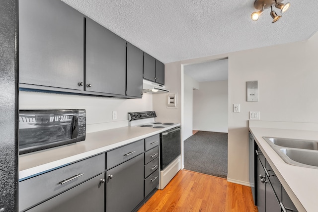 kitchen with white electric stove, a textured ceiling, a sink, light countertops, and under cabinet range hood