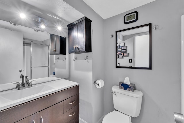 bathroom featuring baseboards, vanity, and toilet