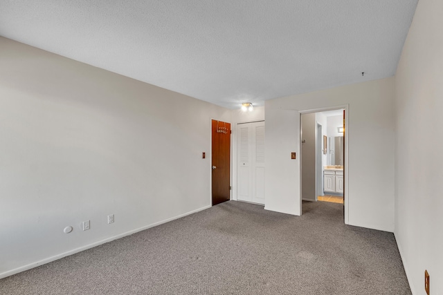 spare room featuring baseboards, carpet floors, and a textured ceiling