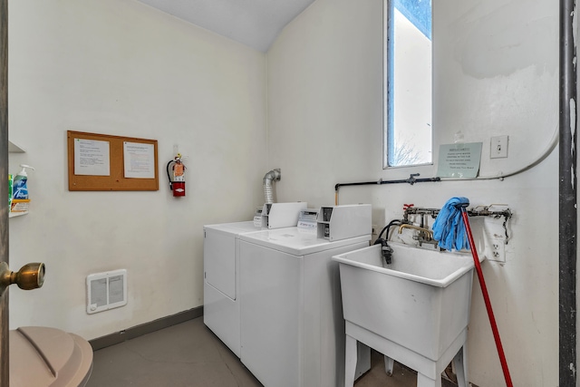 laundry room featuring washer and dryer, baseboards, a sink, and visible vents