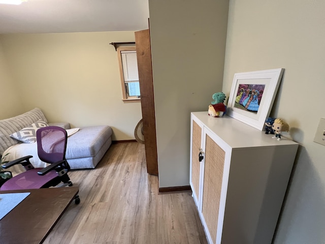 bedroom with light wood-type flooring and baseboards