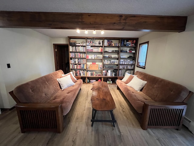 sitting room with beamed ceiling and wood finished floors