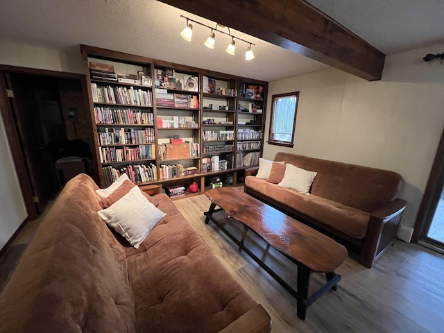 living area featuring beamed ceiling, track lighting, and wood finished floors