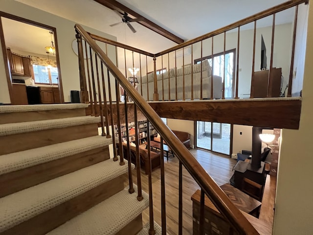stairs with wood finished floors and a ceiling fan