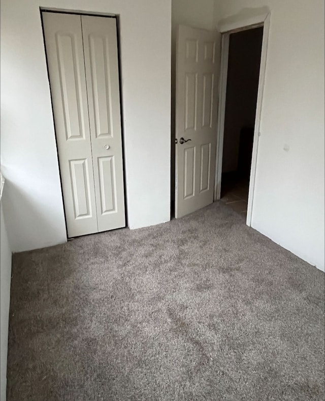 unfurnished bedroom with carpet and a closet