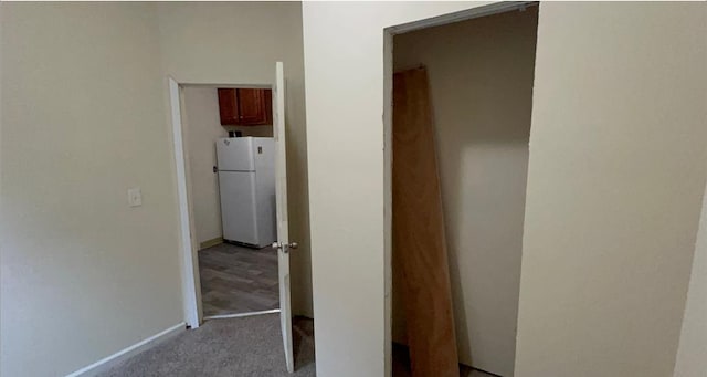 hallway featuring baseboards and carpet flooring
