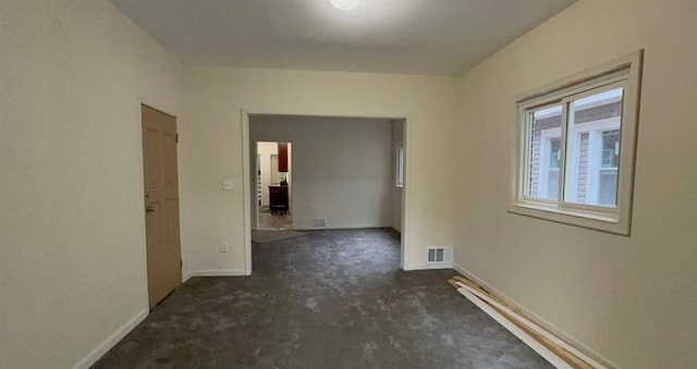 carpeted empty room featuring baseboards and visible vents