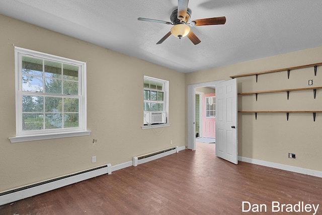 spare room featuring a baseboard heating unit, plenty of natural light, and ceiling fan