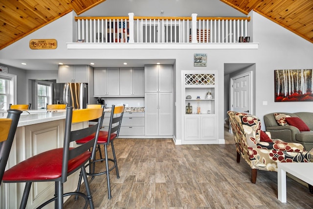 1219 Nokomis Dr, Gladwin, MI 48624 - kitchen featuring stainless steel fridge, wood finished floors, wood ceiling, and high vaulted ceiling
