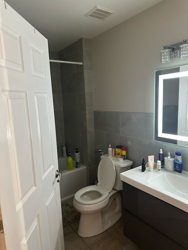 full bathroom featuring vanity, visible vents, toilet, tile walls, and tile patterned floors
