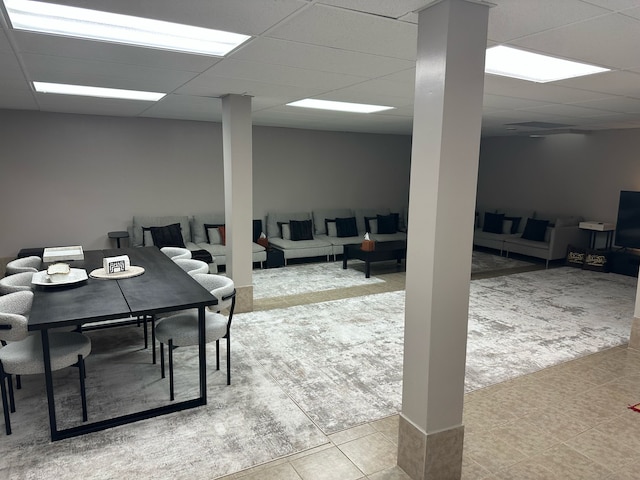 carpeted dining area featuring tile patterned flooring and a drop ceiling