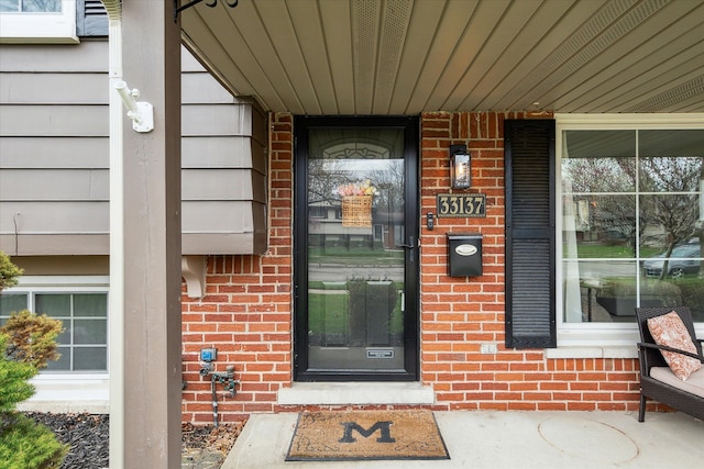 entrance to property featuring brick siding