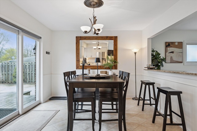 dining room with an inviting chandelier, light tile patterned floors, and a healthy amount of sunlight