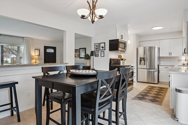 dining space with an inviting chandelier and light tile patterned floors