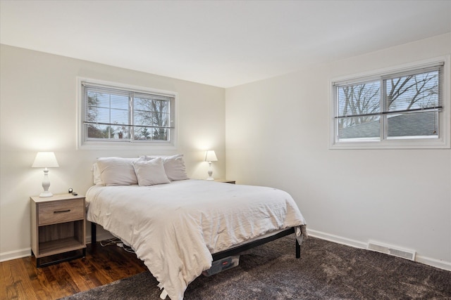 bedroom with baseboards, visible vents, and multiple windows