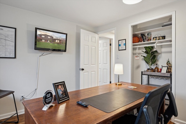 home office featuring baseboards and wood finished floors